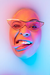 Image showing Beautiful female face in the milk bath with soft glowing in blue-pink neon light