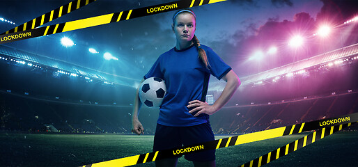 Image showing Football or soccer player on stadium background behind limiting tapes with word Lockdown