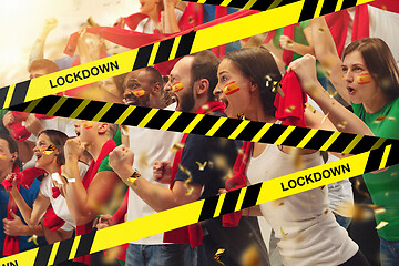 Image showing Female and male soccer fans cheering for favourite sport team with bright emotions, excited, wondered behind the limiting tapes with Lockdown