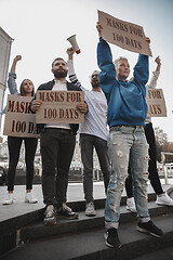 Image showing Group of activists protesting, supporting masks for 100 days in America. Look angry, hopeful, confident. Banners and smoke. Coronavirus.