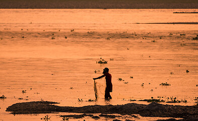 Image showing Asian Woman fishing in the river, silhouette at sunset