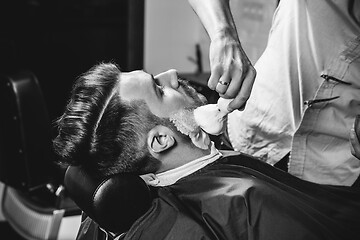 Image showing Client during beard shaving at barbershop.