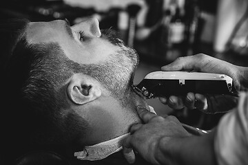 Image showing Client during beard shaving at barbershop.