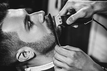 Image showing Client during beard shaving at barbershop.