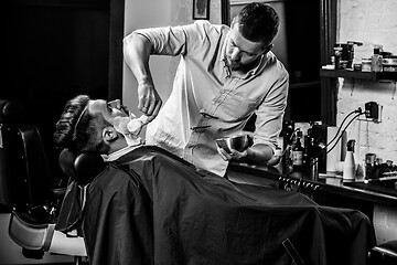 Image showing Client during beard shaving at barbershop.