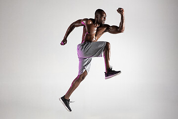 Image showing Young african-american bodybuilder training over grey background