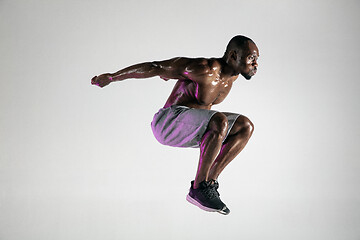 Image showing Young african-american bodybuilder training over grey background