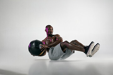 Image showing Young african-american bodybuilder training over grey background