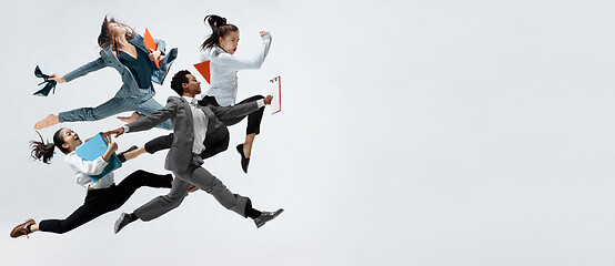 Image showing Happy business women and african man dancing isolated on white.