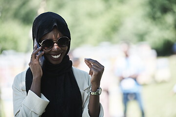 Image showing african woman using smartphone wearing traditional islamic clothes