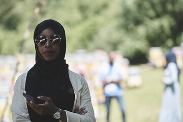 Image showing african woman using smartphone wearing traditional islamic clothes