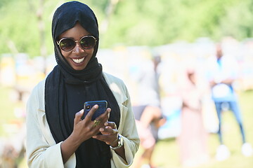 Image showing african woman using smartphone wearing traditional islamic clothes