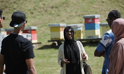 Image showing woman giving presentation to group of business investors on local honey production farm