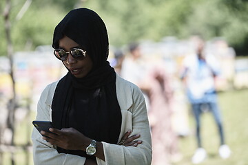 Image showing african woman using smartphone wearing traditional islamic clothes