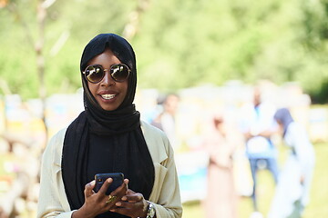 Image showing african woman using smartphone wearing traditional islamic clothes