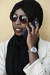 Image showing african woman using smartphone wearing traditional islamic clothes