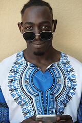 Image showing portrait of a smiling young african man wearing traditioinal clothes