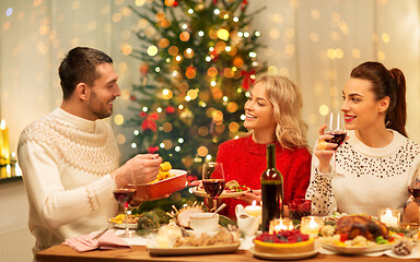 Image showing happy friends having christmas dinner at home