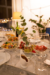 Image showing table served with plates, wine glasses and food