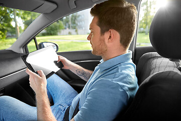 Image showing male passenger using tablet computer in taxi car