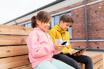 Image showing children with smartphones sitting on street bench