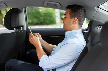 Image showing passenger or businessman using smartphone in car