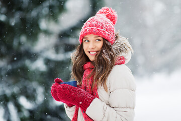 Image showing happy young woman with tea cup in winter park