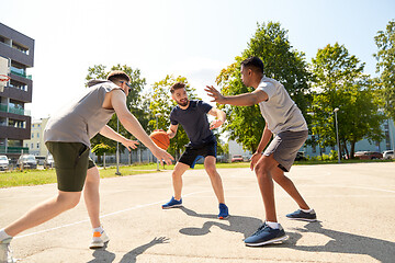 Image showing group of male friends playing street basketball