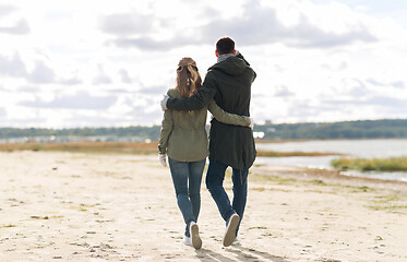 Image showing couple walking along autumn beach and hugging