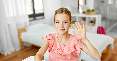 Image showing happy little girl waving hand at home