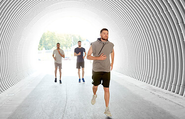 Image showing young men or male friends running in tunnel