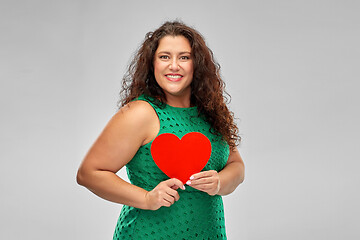 Image showing happy woman in green dress holding red heart