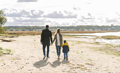 Image showing happy family walking along autumn beach