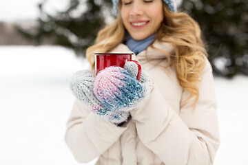 Image showing happy young woman with tea cup in winter park