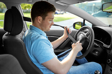 Image showing man or car driver fastening seat belt