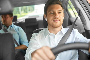 Image showing male driver with wireless earphones driving car