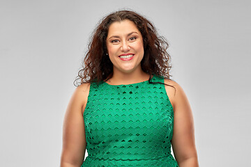 Image showing happy woman in green dress over grey background