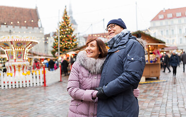 Image showing happy senior couple hugging at christmas market