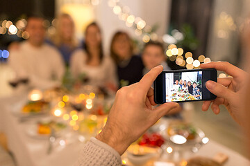 Image showing man taking picture of family at dinner party