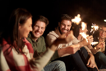 Image showing happy friends with sparklers at night outdoors