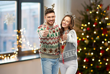 Image showing couple in christmas ugly sweaters shows thumbs up