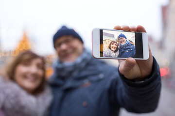 Image showing senior couple taking selfie at christmas market