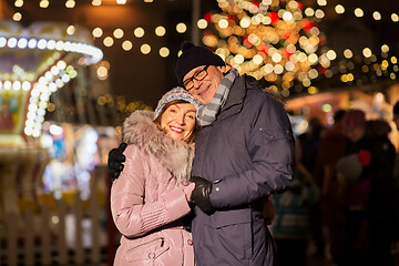 Image showing happy senior couple hugging at christmas market