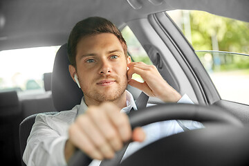 Image showing man or driver with wireless earphones driving car