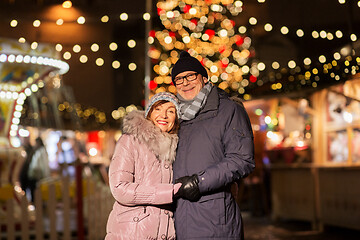 Image showing happy senior couple hugging at christmas market