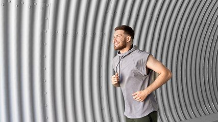 Image showing sporty young man running in tunnel