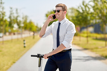 Image showing businessman with scooter calling on smartphone