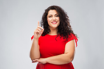 Image showing happy woman in red dress pointing finger up