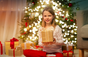 Image showing smiling girl with christmas gift at home