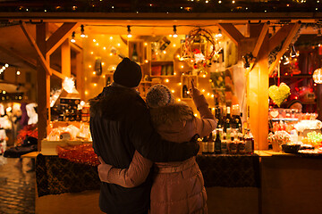 Image showing happy senior couple hugging at christmas market